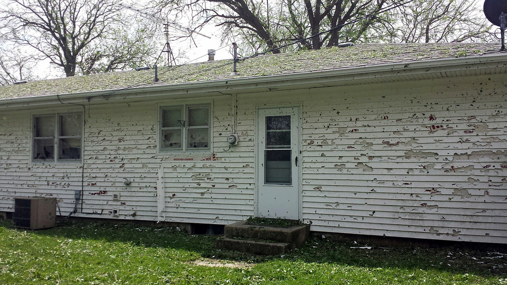 White home with hail damage on the siding