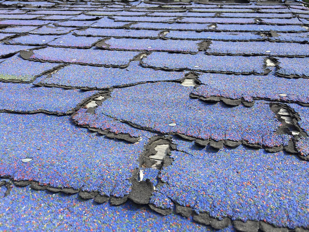 hail damaged roof shingles with torn up edges